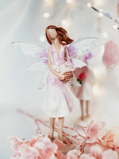 Andělka figurka na postavení ve světle fialových midi šatech s košíkem květin